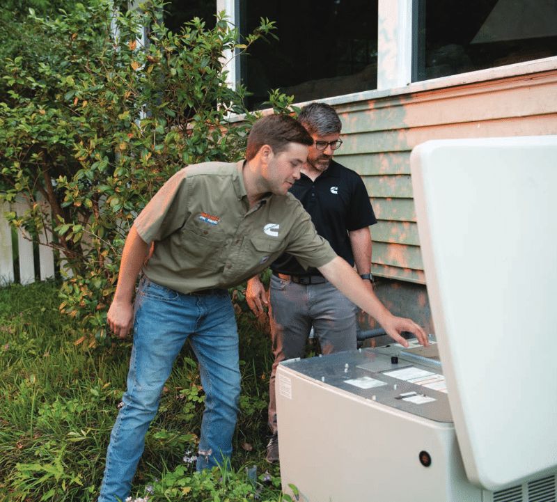 Technicians servicing Cummins RS20A home standby generator